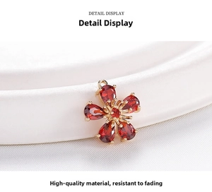 Macro shot of gold-plated flower pendant with red zircon stones on white silk