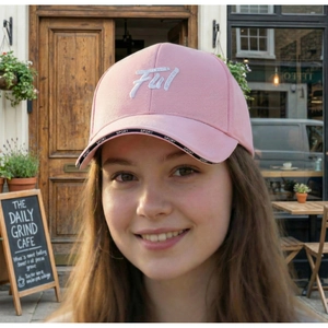 Detailed close-up of pink baseball cap featuring white 7W embroidery and Sport brim strap
