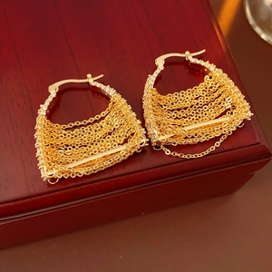 Detailed view of gold chain drop earrings with sparkling cubic zirconia on a wooden box