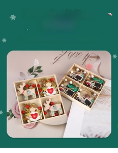 Flat lay of wooden Christmas tree ornaments with reindeer and angel figurines in storage boxes