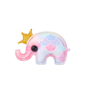 Detailed view of elephant shaped bath bomb with pink and blue scales and golden crown