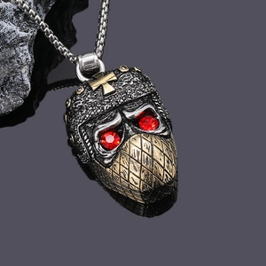 Macro shot of vintage ninja pendant with red gemstones and gold cross detail
