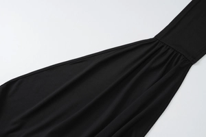 Vue détaillée du tissu plissé noir montrant les coutures et la texture de qualité