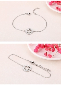 Detail eines silbernen Smiley-Armbands mit funkelnden Strasssteinen und Karabinerverschluss
