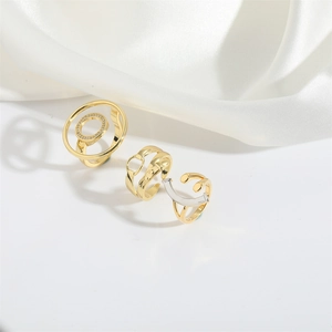 Detailed view of three gold and silver geometric rings on soft white silk fabric
