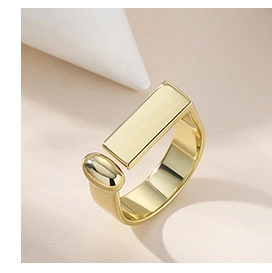 Macro view of a gold geometric open ring featuring a rectangle and oval bead design