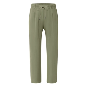 Detail view of the drawstring elastic waist and pleated texture of olive linen pants