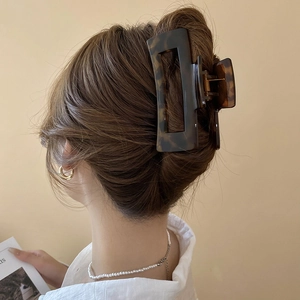 Macro shot of large tortoise shell hair claw clip holding a French twist hairstyle