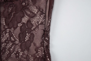Macro view of high-quality lace texture and concealed side zipper on a deep purple dress