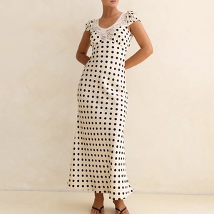 Detailed close-up of lace splicing on the V-neckline of a white polka dot satin dress