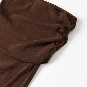Detail of dark brown glitter knit fabric with elegant pleated texture and subtle shimmer