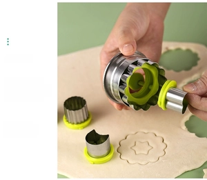 Detail of stainless steel cookie mold pressing round and star shapes on dough