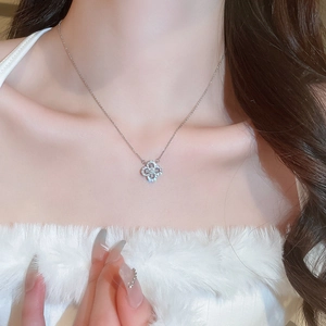 Macro detail of silver floral pendant necklace with sparkling cubic zirconia on a model