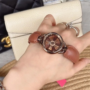 Close-up of a women's watch featuring a rotating floral dial and brown leather strap