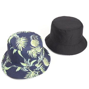 Detail of reversible cotton bucket hat featuring pineapple tropical print and plain black side