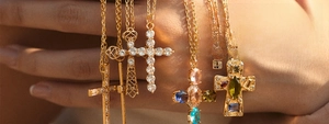 Close-up of gold-plated cross necklaces with zircon inlays and colorful gemstones