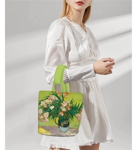 Detail view of Van Gogh Oleanders print canvas bucket bag with vibrant green handles