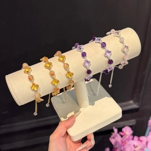Détail de bracelets trèfle en perles de cristal multicolores sur supports à bijoux