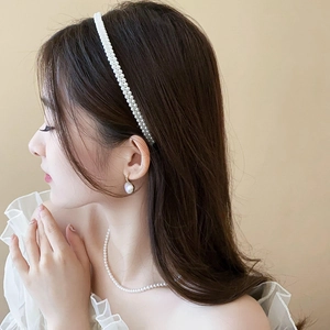 Détail d'un élégant serre-tête en perles blanches à double rangée avec parure assortie