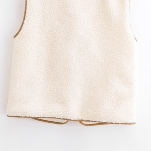 Chic beige faux shearling vest with brown piping trim and soft curly texture detail
