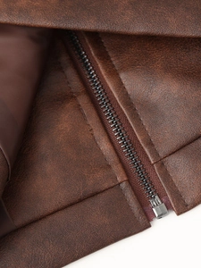 Vue détaillée de la fermeture éclair en métal et du cuir brun d'une veste rétro