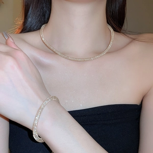 Detail of champagne gold mesh necklace and bracelet set filled with sparkling zircons