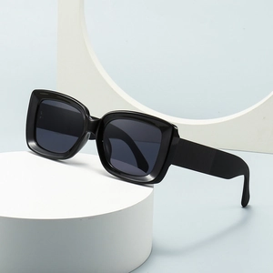 Modern square checkered sunglasses with bold black frames and dark lenses on white pedestal