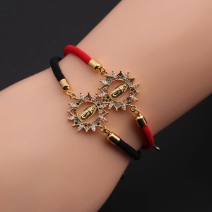 Detailed shot of braided rope bracelets with zircon-inlaid religious Sun pendants