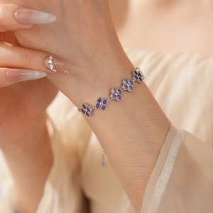 Detailed close-up of a silver flower bracelet with shimmering purple zircon stones