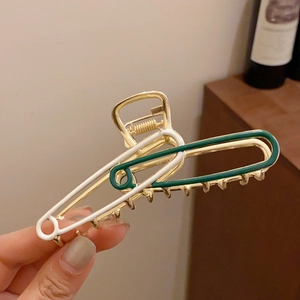 Detail of large safety pin style hair claw clip with green and white drip oil finish
