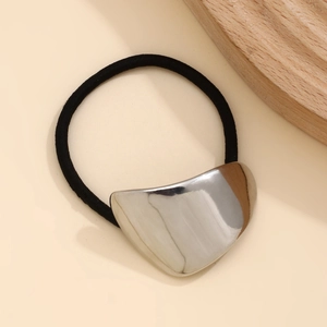 Detailed view of polished silver irregular metal ornament on black elastic hair tie