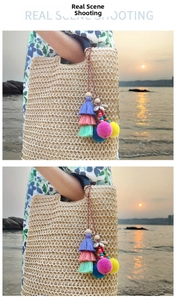Detail of bohemian bag charm with colorful tassels, pom-poms and shells on woven tote