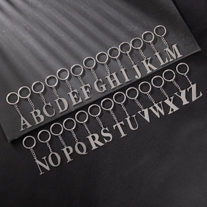 Set of 26 silver stainless steel uppercase letter keychains A-Z on a dark background