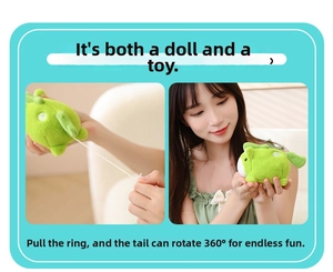 Detail of green plush animal toy with pull-string mechanism for 360-degree tail rotation