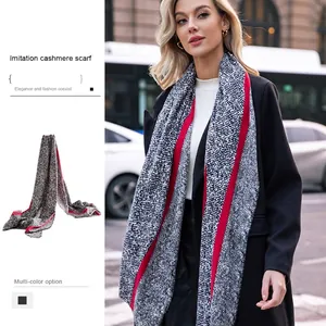 Elegant snake print cashmere scarf with red contrast borders shown on a fashion model