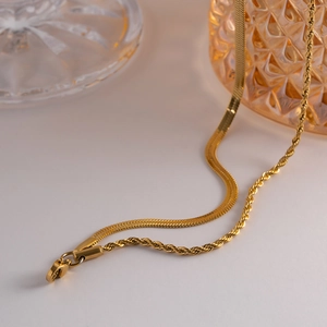 Detailed view of layered gold snake and twisted chains with a secure lobster clasp