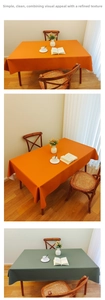 Detail view of cream white faux leather tablecloth in orange and green tones