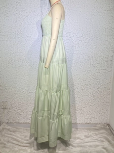 Detail of light green striped maxi dress with tiered cake skirt and ruched waistline