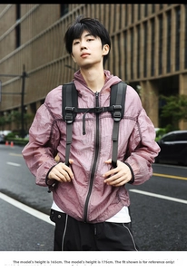 Outdoor street view of a lightweight hooded sun protection jacket with back view of backpack