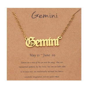 Detail of Gemini zodiac necklace in gold finish on a decorative kraft paper card