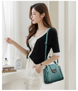 Model wearing dark green soft leather crossbody bag with adjustable shoulder strap