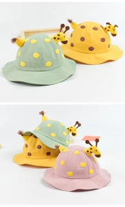 Close-up of 3D giraffe horns and felt polka dots on cotton toddler sun hats
