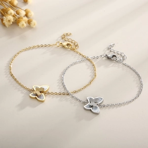 Dettaglio macro di braccialetti a farfalla oro e argento con inserti in conchiglia e glitter