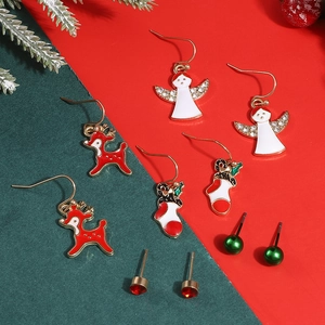 Detail of 5-pair Christmas earring set with reindeer, angels and socks on festive background