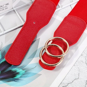 Detail of red leather waist belt featuring a classic golden double-ring metal buckle