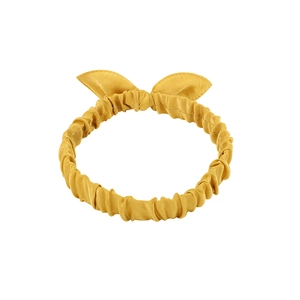 Detail of ginger yellow bunny ear headband featuring pleated satin fabric and soft texture