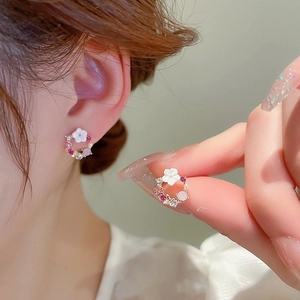 Close-up of floral wreath earring with pink crystals and pearls worn by a model