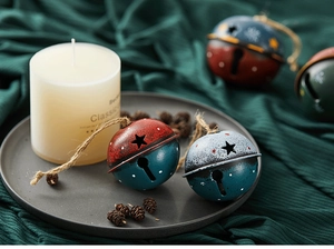 Artistic close-up of festive metal Christmas bells with star cutouts and pine cones