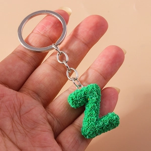 Detail of green floral capital letter Z keychain with silver ring held by hand