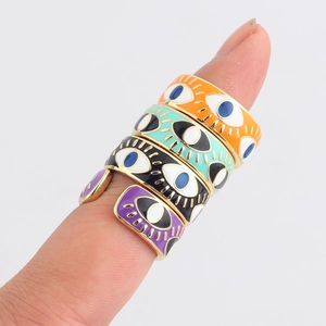 Detailed close-up of stacked colorful Evil Eye enamel rings in gold plating